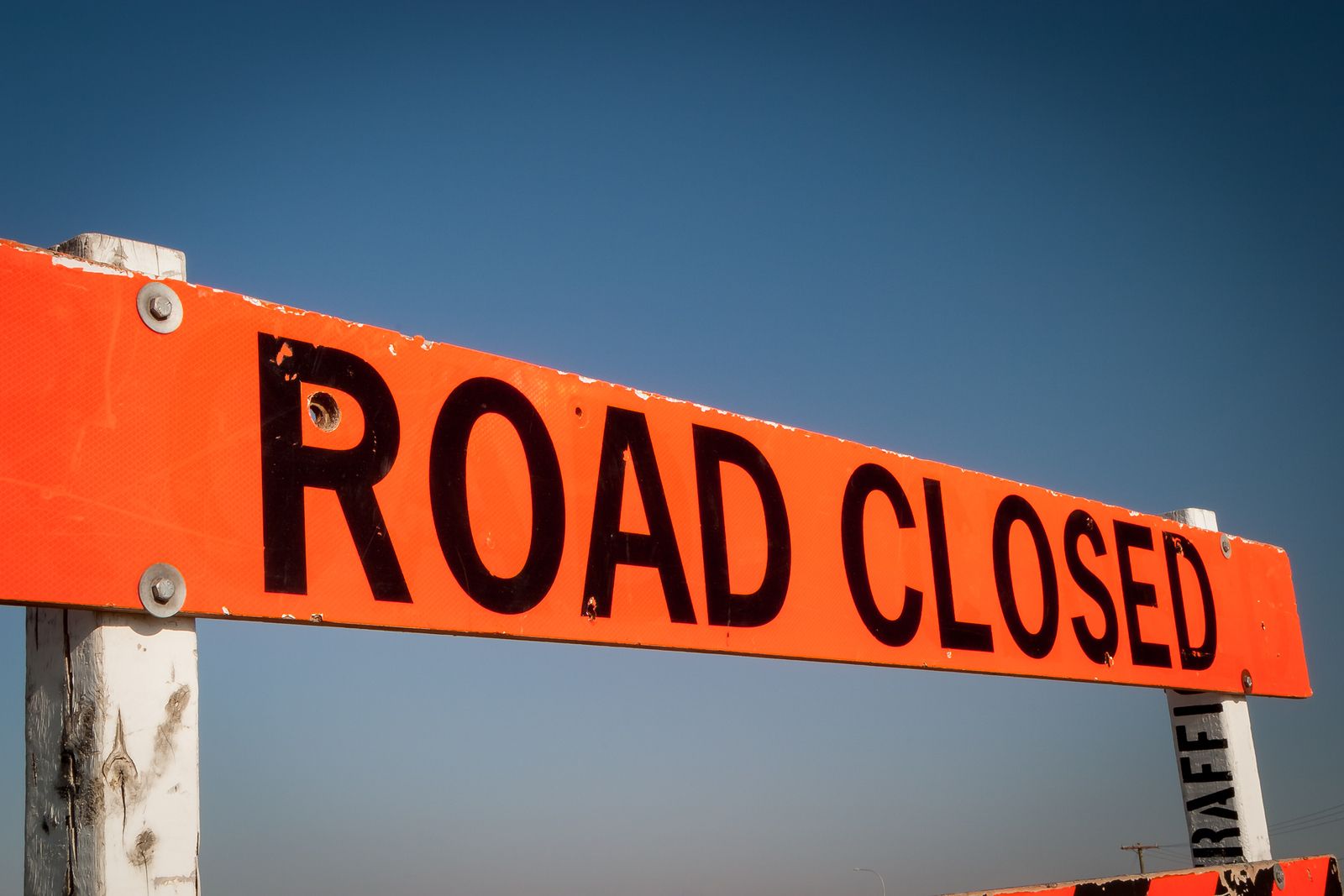 Orange and black traffic sign that reads "Road Closed"